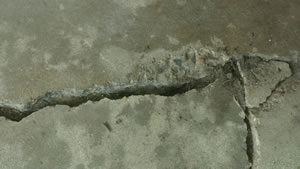 Garage showing cracks in the concrete, before being fixed.