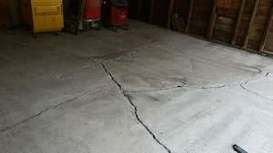 Garage showing cracks in the concrete, before being fixed.